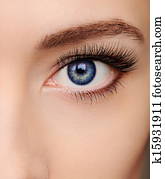 Closeup beautiful blue woman eye with long salon lashes looking Closeup beautiful blue woman eye with long salon lashes looking