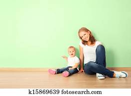 familia feliz, de, madre y niño, es, un, bebé, sentado sobre el piso, en, un, vacío, hogar, pared, en, el, habitación