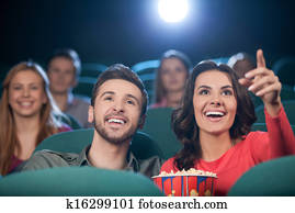 Happy couple at the cinema. Cheerful young couple watching movie at the cinema Happy couple at the cinema. Cheerful young couple watching movie at the cinema