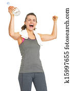 Happy fitness young woman with bottle of water rejoicing success
