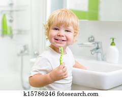 Happy kid or child brushing teeth in bathroom. Dental hygiene. Happy kid or child brushing teeth in bathroom. Dental hygiene.