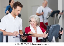 instrutor, explicando, programa, para, mulher sênior, em, ginásio