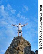 Man celebrating reaching the top of a mountain