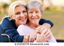 middle aged woman embracing disabled senior mother