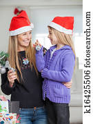 Mother And Daughter Decorating Christmas Tree