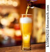 pouring beer in glass on bar or pub desk