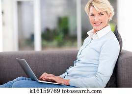 pretty senior woman at home using laptop