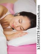 Pretty young asian woman sleeping in her bed