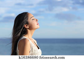 Profile of a beautiful arab woman breathing fresh air in the beach