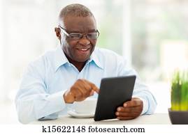 senior african american man using tablet computer at home