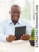 senior african man holding tablet computer