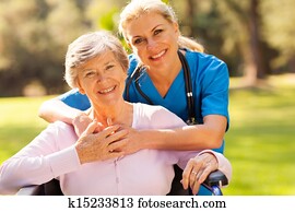 senior woman in wheelchair outdoors with caring caregiver senior woman in wheelchair outdoors with caring caregiver