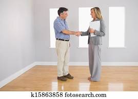 Serious realtor shaking the hand of her buyer