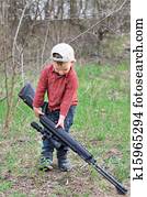 Small boy lugging a sporting rifle