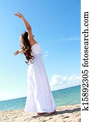 Woman relaxing at the beach with arms open enjoying her freedom