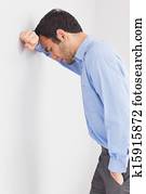 Worried man leaning his head against a wall