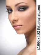 Beautiful make-up. Portrait of confident women with make-up looking at camera while isolated on grey