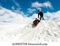 Boy and dad sledding in winter Boy and dad sledding in winter