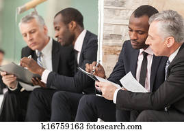 Businessmen looking at paper Businessmen looking at paper