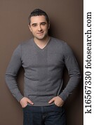 Confident mature man. Cheerful middle-aged man standing with his hands in pockets and smiling at camera