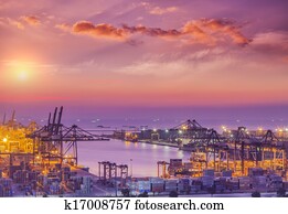 Container Cargo freight ship with working crane bridge in shipyard at dusk for Logistic Import Export background