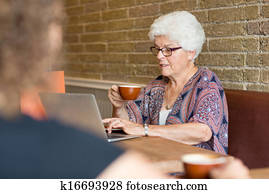 Customer Using Laptop While Having Coffee In Cafe