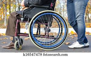 Disabled man in a wheelchair with a carer Disabled man in a wheelchair with a carer