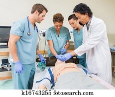Doctor Instructing Nurses In Hospital Room