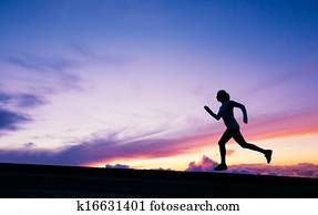 Female runner silhouette, running into sunset Female runner silhouette, running into sunset