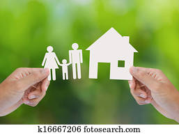 Hand hold house and family on green