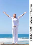 middle aged woman arms reach out on beach