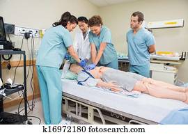 Nurse Performing CPR On Dummy Patient Nurse Performing CPR On Dummy Patient