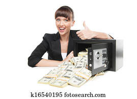 Safe with money. Happy young businesswoman in formalwear sitting at the table near the safe full of money while isolated on white 