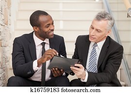 Senior businessman and mid adult businessman working together
