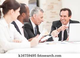 Smiling business people with paper work in board room