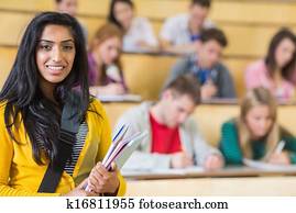 Smiling female with students sitting at the lecture hall Smiling female with students sitting at the lecture hall