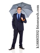 successful businessman holding umbrella