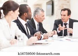 Team of a colleagues working on business plans together Team of a colleagues working on business plans together