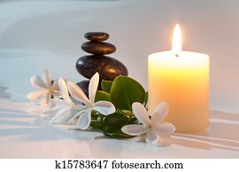 tiare flowers, candle and stones