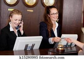 Two receptionists at a reception desk Two receptionists at a reception desk