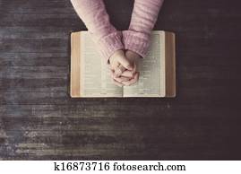 Woman praying on table Woman praying on table