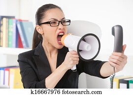 Woman with megaphone. Angry young businesswoman shouting at megaphone while talking on the phone