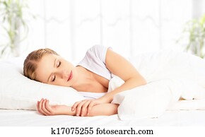 beautiful woman sleeping and smiles in his sleep in  bed 