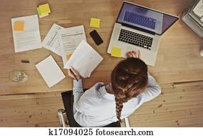 Businesswoman working at her office desk with documents and laptop