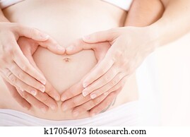 Couple Expecting Baby. Pregnant Belly with fingers Heart symbol Couple Expecting Baby. Pregnant Belly with fingers Heart symbol