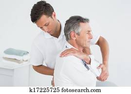 Male chiropractor examining mature man Male chiropractor examining mature man