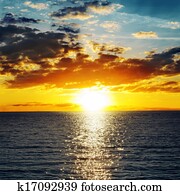 orange sunset over darken water