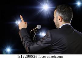 Rear view of a speaker speaking at the microphone Rear view of a speaker speaking at the microphone
