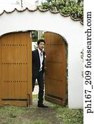 Young man walking through wooden door