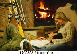Couple relax by fireplace